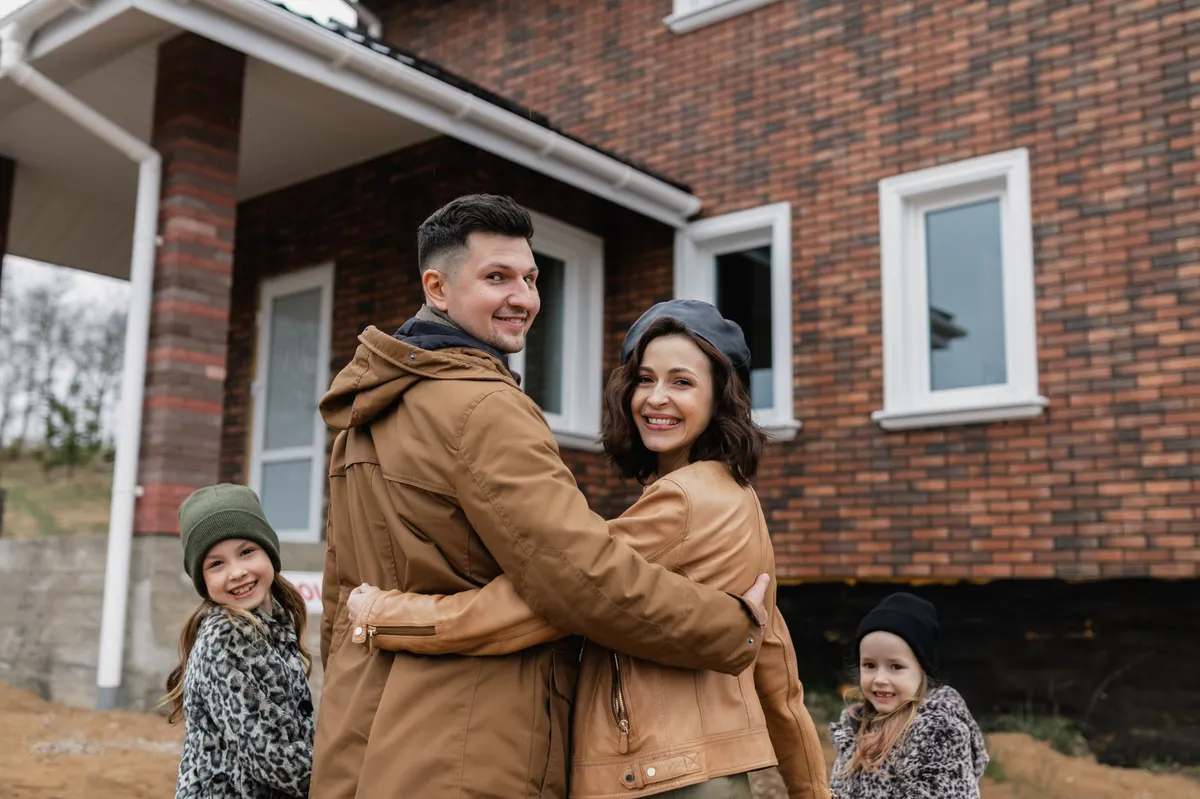 happy family in front of their new home